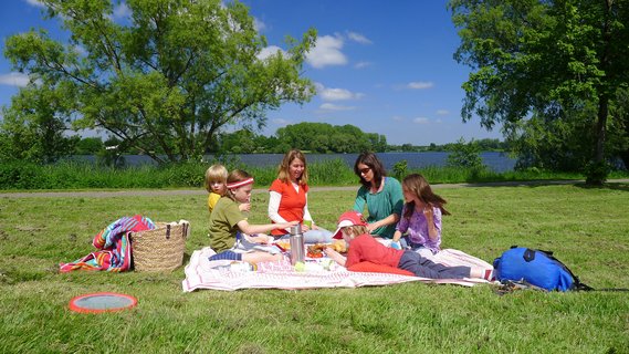 Eine große Familie macht ein Picknick auf der Wiese am Vörder See