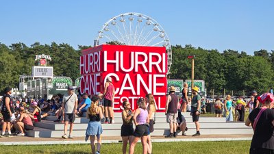 Menschen versammeln sich um einen auffälligen Festival-Würfel, um die Atmosphäre des Hurricane Festivals zu erleben.