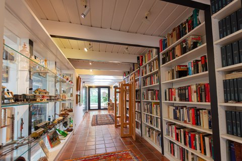 Flur am Eingang in Walter Kempowskis Haus mit langer Bücherwand Regal mit Sammlerstücken und Modellbau