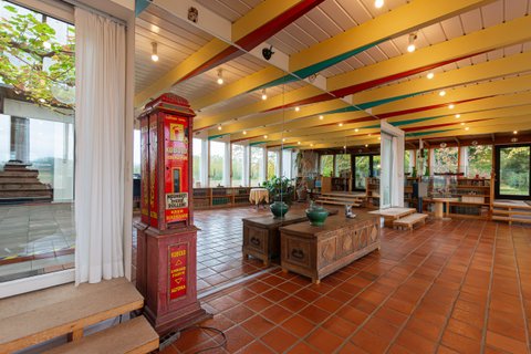 Im Veranstaltungsraum im Haus Kreienhoop steht ein großer roter Automat neben einer alten Holztruhe an der großen Spiegelwand