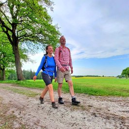 Paar wandert beschwingt auf einem Feldweg