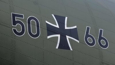 Die Schrift 50+66 auf der matt-grünen Transall, wobei das Plus einem eisernen Kreuz der Bundeswehr entspricht
