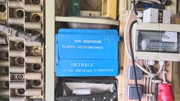 An der Wand hängt ein blaues Urinal zum Aufklappen aus Metall