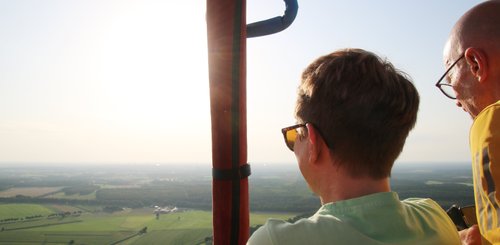 Petra blickt gegen die Abendsonne in die Landschaft, daneben ist Udo teiwleise zu sehen