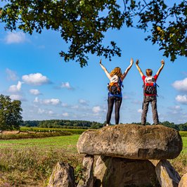 Zwei weibliche Wanderer stehen auf dem Großsteingrab Steinalkenheide und schauen in die Ferne