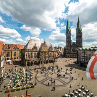 Blick von oben auf den Bremer Marktplatz mit dem UNESCO-Welterbe Rathaus, rechts ist die Bremer Speckflagge zu sehen