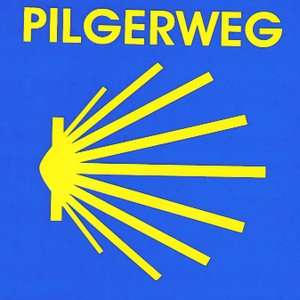 Logo Pilgerweg - eine gelbe, wie eine Sonne strahlende Muschel auf blauem Grund