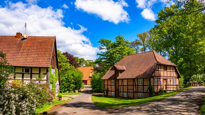 Ensemble aus der historischen Fackwerk-Wassermühle und zwei weiteren Gebäuden an einem geschwungenen Weg in Federlohmühlen