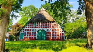 Typisches rotes Fachwerk-Bauernhaus mit grünem Holztor