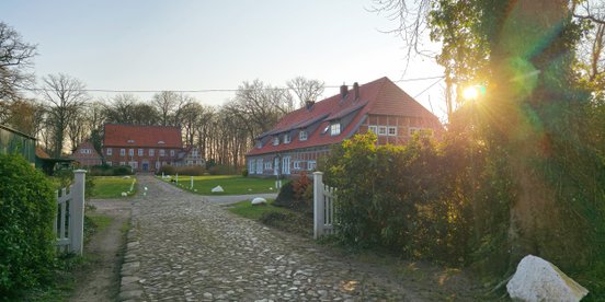 Die Abendsonne scheint gerade noch über dem Dach vom Rittergut Poggemühlen