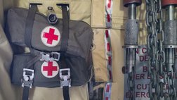 Zwei Erste-Hilfe-Taschen hängen gut sichtbar mit dem roten Kreuz markiert an der Wand