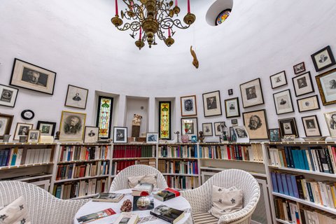 Kleines rundes Turmzimmer mit weißen Wänden, Bildern und Büchern im Haus Kreienhoop