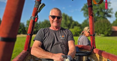 Miroslaw Pszczolka strahlt in die Kamera, während er im Korb des Heißluftballons steht