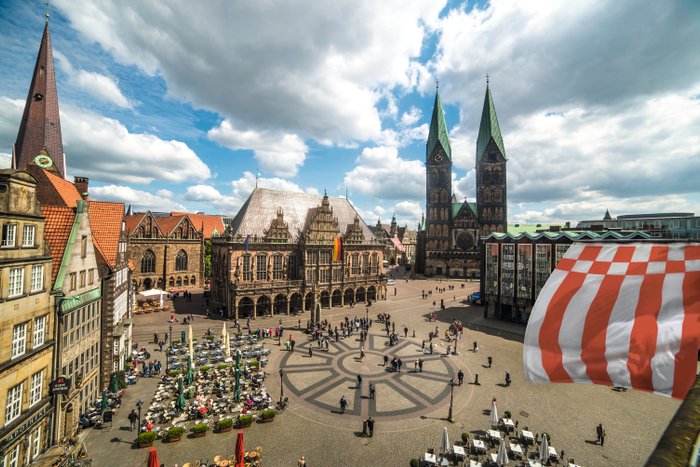 Blick von oben auf den Bremer Marktplatz mit dem UNESCO-Welterbe Rathaus, rechts ist die Bremer Speckflagge zu sehen