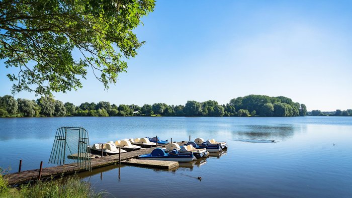 Eine ruhige Stimmung am Vörder See, an dem Tretboote am Steg liegen