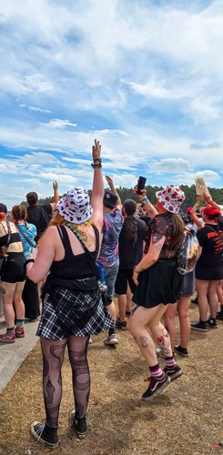 Die lebendige Atmosphäre des Festivals wird durch die tanzenden Menschen und die vielen bunten Outfits unterstrichen.