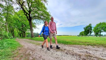 Paar wandert beschwingt auf einem Feldweg