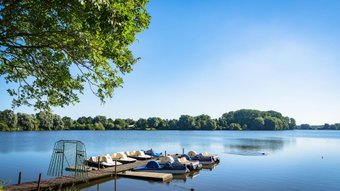 Eine ruhige Stimmung am Vörder See, an dem Tretboote am Steg liegen