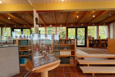 Blick vom Veranstaltungsraum im Haus Kreienhoop auf ein Modell und den Büchergang mit einer großen Fensterfront