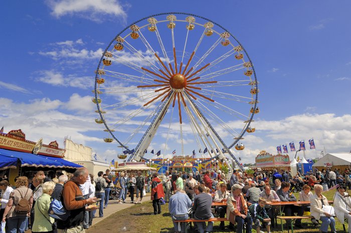 Auf der gut besuchten Tarmstedter Ausstellung steht das Riesenrad hinter Ständen mit Gastronomie 