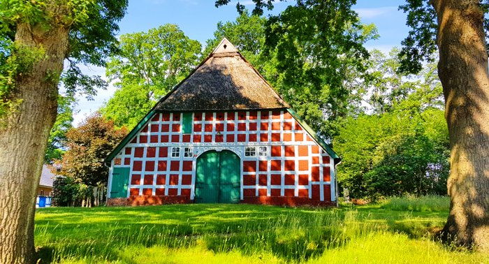 Typisches rotes Fachwerk-Bauernhaus mit grünem Holztor