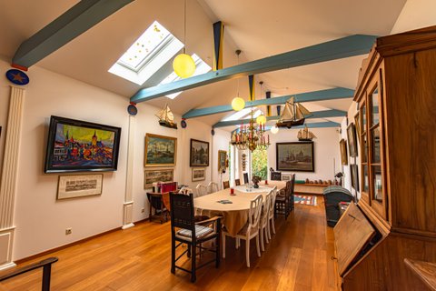 Speiseraum mit blauen Deckenbalken und Gemälden im Haus von Walter Kempowski