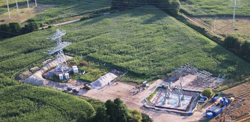 Baustelle an einem Mast einer Hochspannungsleitung