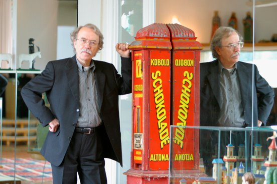 Der inwzischen verstorbene Schriftsteller Walter Kempowski lehnt in seinem Haus an einem roten Automaten