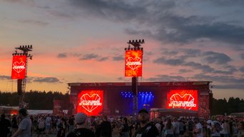 Große rote Displays verkünden „30 Jahre Musik feiern“, umgeben von begeisterten Festivalbesuchern.