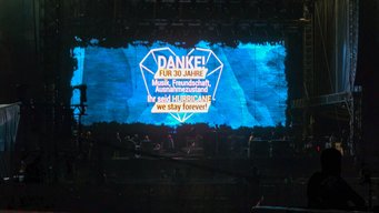 Ein großer Bildschirm zeigt eine Dankesbotschaft für 30 Jahre Musik und Freundschaft beim Hurricane Festival.