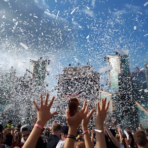 Besucher strecken die Hände hoch im Konfittiregen auf dem Elektropop-Festival Ferdinands Feld