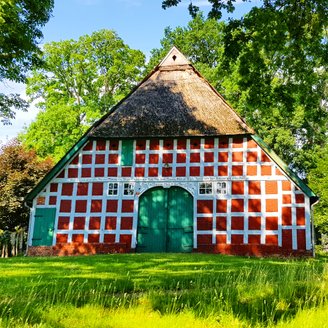 Typisches rotes Fachwerk-Bauernhaus mit grünem Holztor