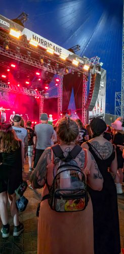 Festivalbesucher genießen die Live-Performance auf der Bühne, umgeben von bunten Lichtern und einer energiegeladenen Atmosphäre.