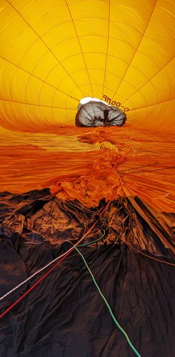 Hochformatiger Blick in den Heißluftballon, der noch am Boden liegt und sich mit Luft füllt