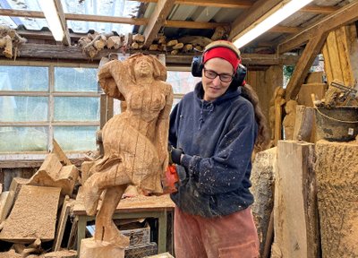 Holzspäne fliegen durch die Luft, wenn Ragna sägt