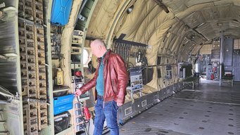 Achim Figgen präsentiert das blau lackierte Urinal an der Seite des Frachtraums