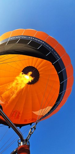 Blick von unten in den Heißluftballon, die Flamme erwärmt die Luft