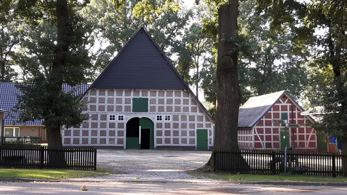 Idyllische Ansicht eines Bauernhofs mit Fachwerkhaus und Nebengebäuden 