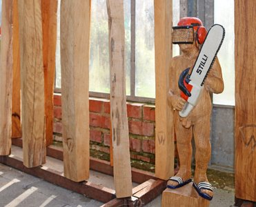 Nackter Mann mit Kettensäge