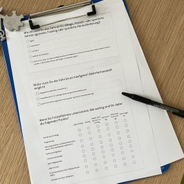 Ein Ausdruck eines Umfrage-Formulars liegt in einem Klemmbrett bereit zum Ausfüllen
