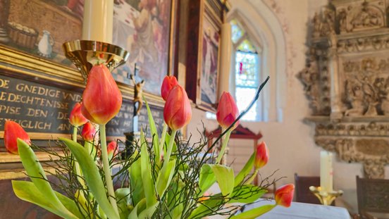 Ein roter Tulpenstrauß steht auf dem Altar der Oeser Kirche