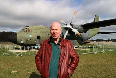 Achim Figgen steht in der Sonne vor der Transall auf dem Flugplatz