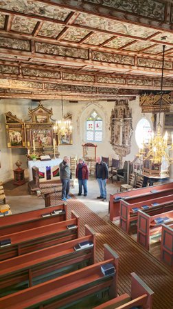 Blick von oben auf den Altarraum der Kirche in Oese mit einer Gruppe von drei Personen