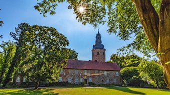 Das ehemalige Kloster aus rotem Backstein an einem sonnigen Tag im Stadtpark Zeven