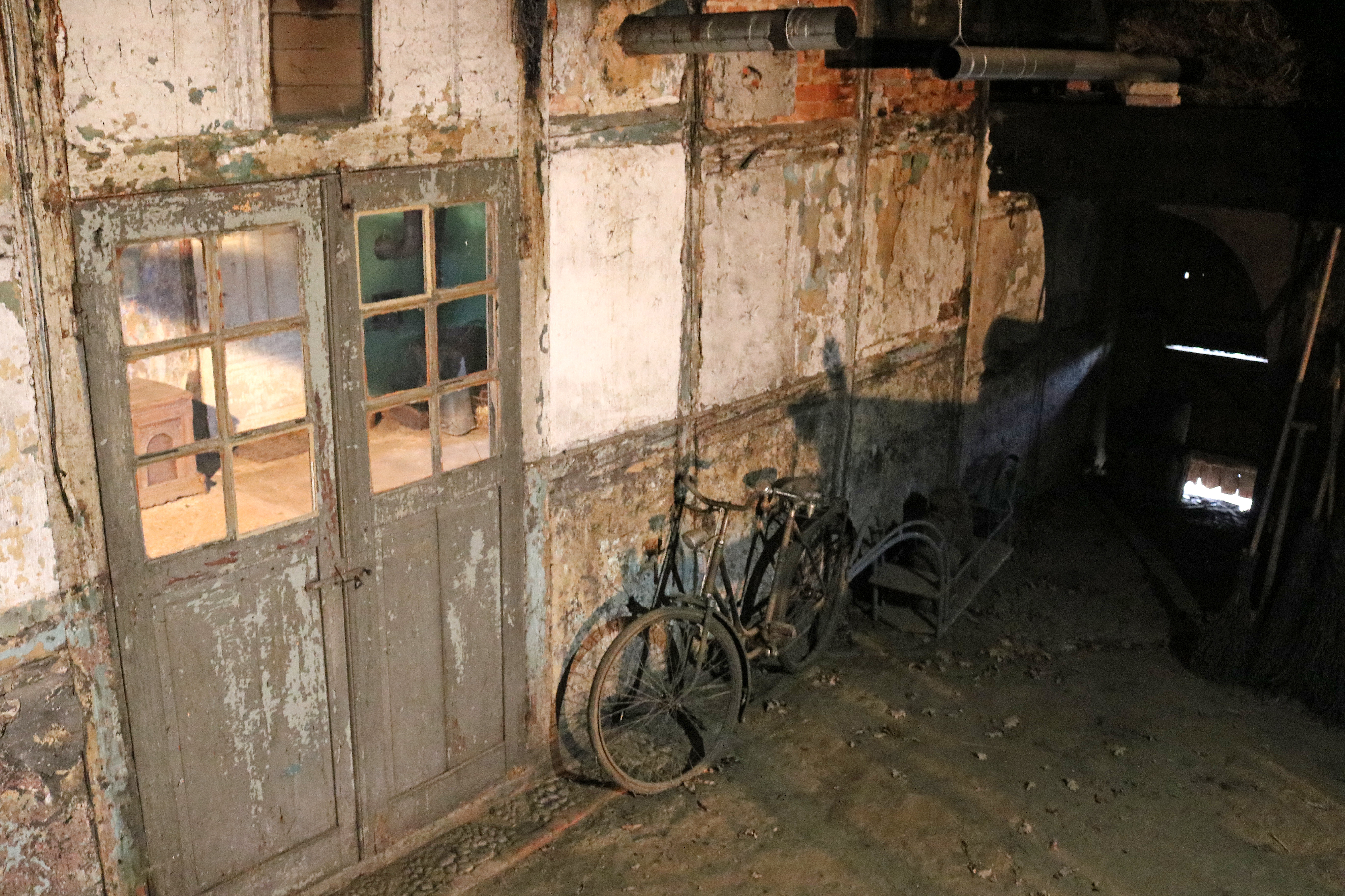 Blick auf die Scherwand auf der Dielenseite mit dem alten Fahrrad