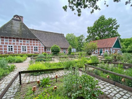 Hinter einem Bauern- und Apothekergarten ist das historische Haus am See mit sienem Fachwerk zu sehen