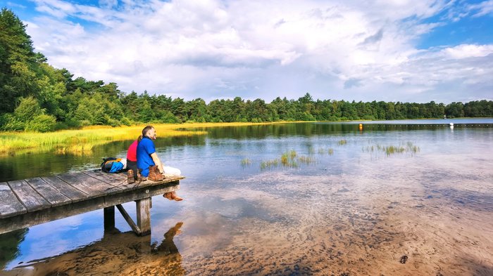 Wanderer sitzen auf dem Steg am Bullensee in Rotenburg, Foto: Stadt Rotenburg (Wümme)